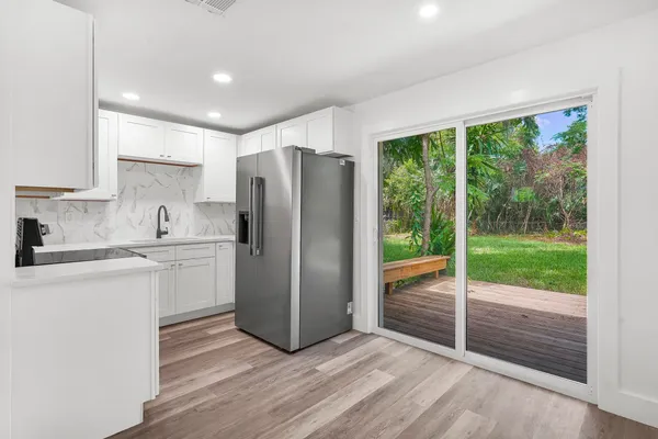 a kitchen with a refrigerator and a stove top oven