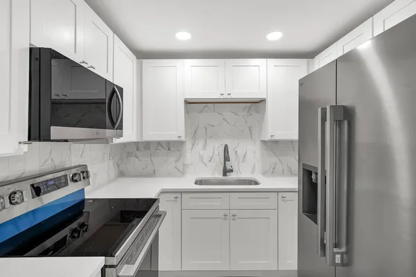 a kitchen with a refrigerator sink and cabinets