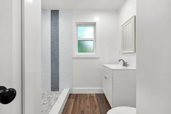 an empty room with a window and wooden floor