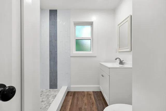 an empty room with a window and wooden floor