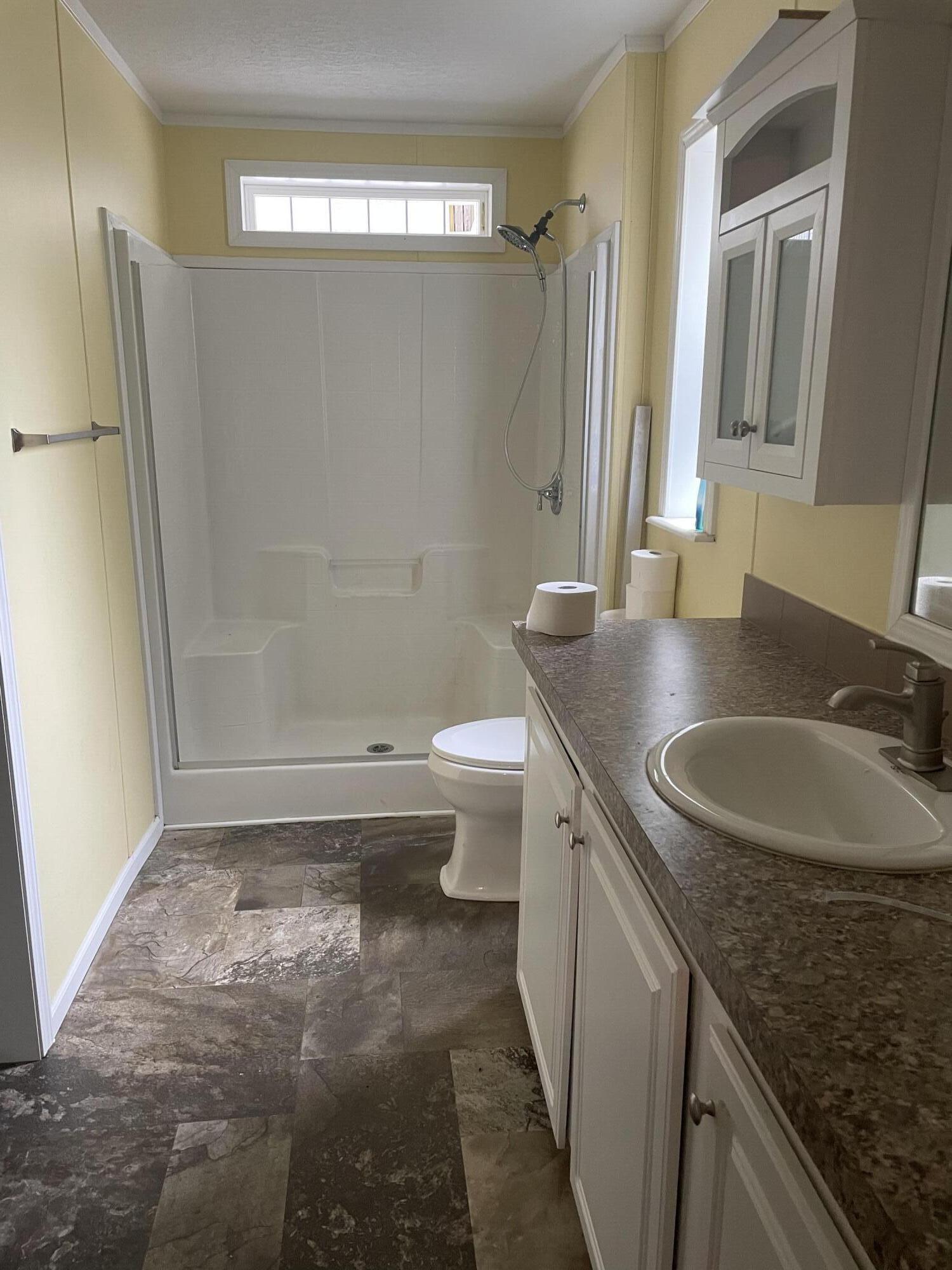1412 Cape Lane Niceville, FL 32578 - Photo 15 of 23 a bathroom with a granite countertop sink a toilet a mirror and shower