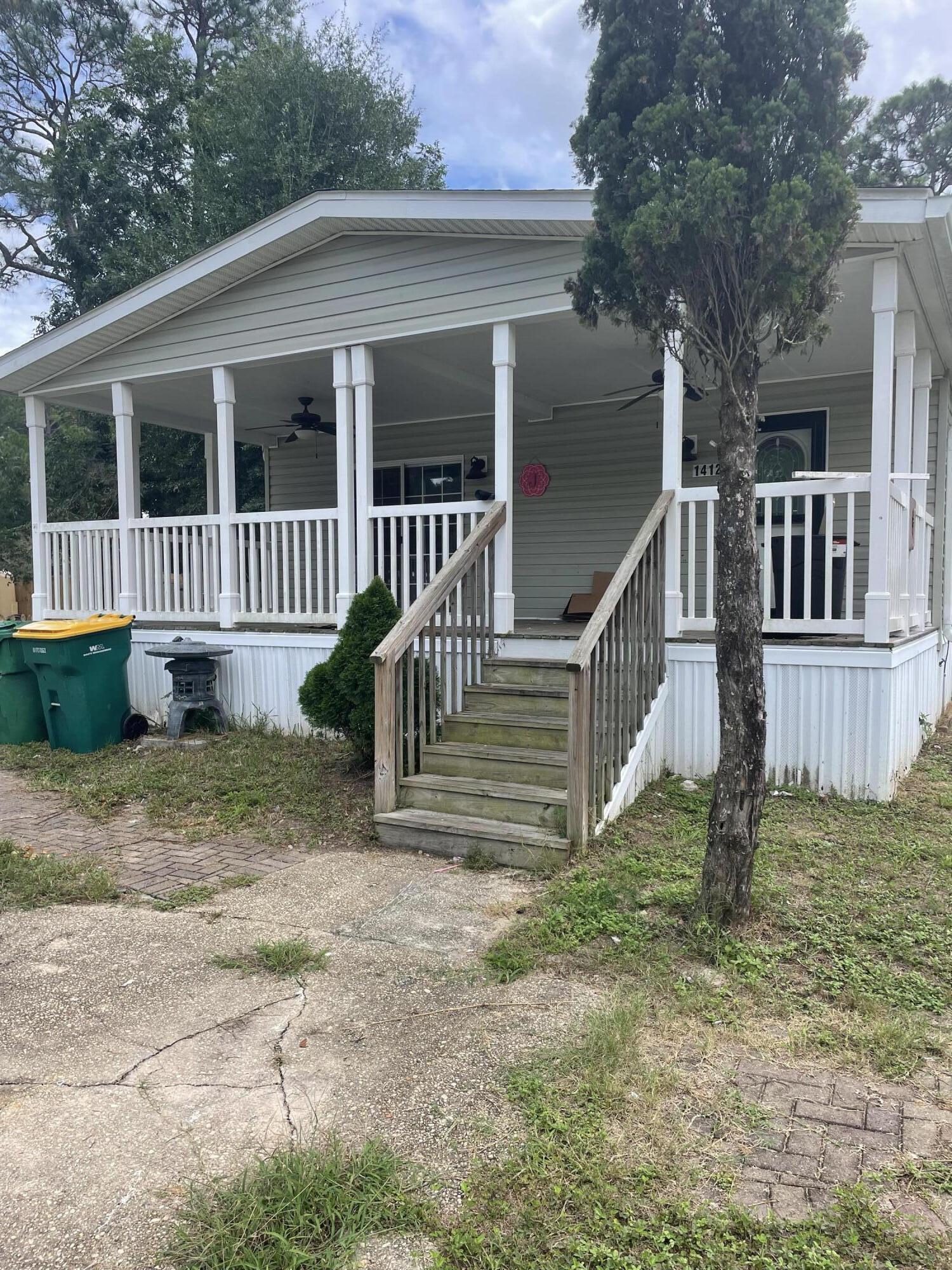 1412 Cape Lane Niceville, FL 32578 - Photo 2 of 23 a view of a house with a yard and large trees