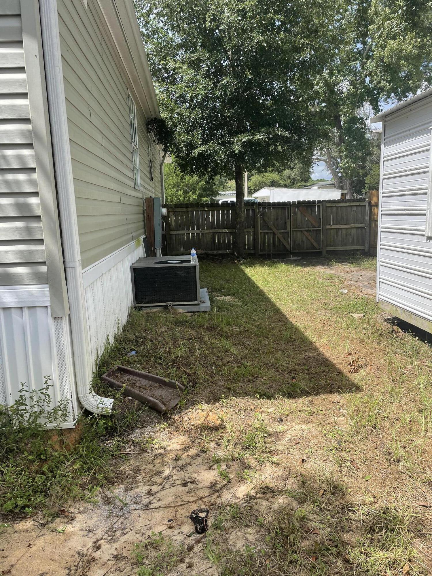 1412 Cape Lane Niceville, FL 32578 - Photo 22 of 23 a view of a backyard with large tree and wooden fence