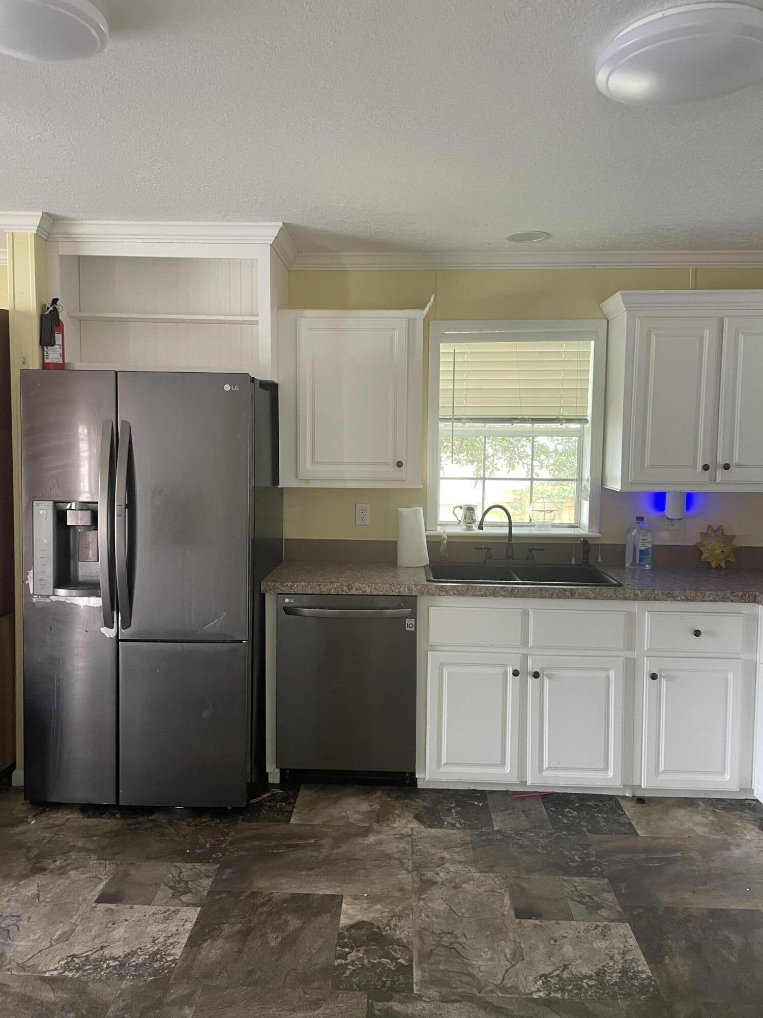 1412 Cape Lane Niceville, FL 32578 - Photo 6 of 23 a kitchen with granite countertop a refrigerator sink and cabinets