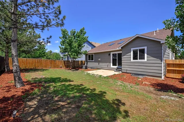 a backyard of a house with table and chairs