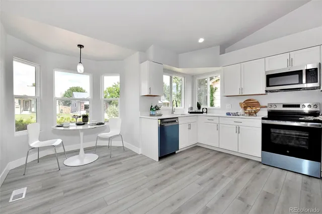 a kitchen with a sink cabinets and wooden floor