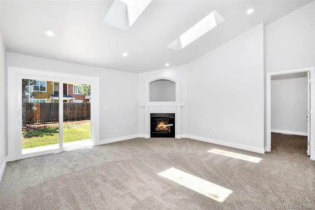 a view of an empty room with a fireplace and a window
