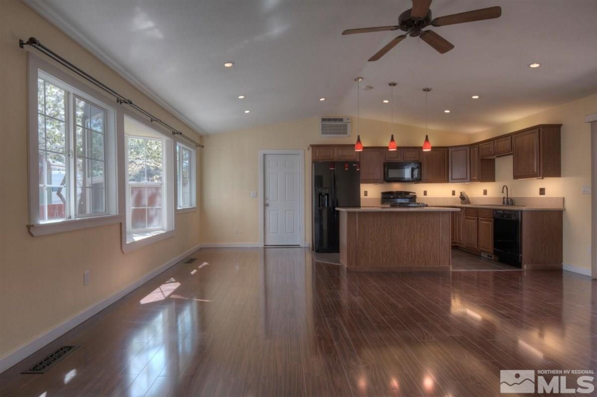 2975 Andrea Street Reno, NV 89503 - Photo 4 of 28 a kitchen with stainless steel appliances kitchen island granite countertop a stove top oven a sink with wooden floors