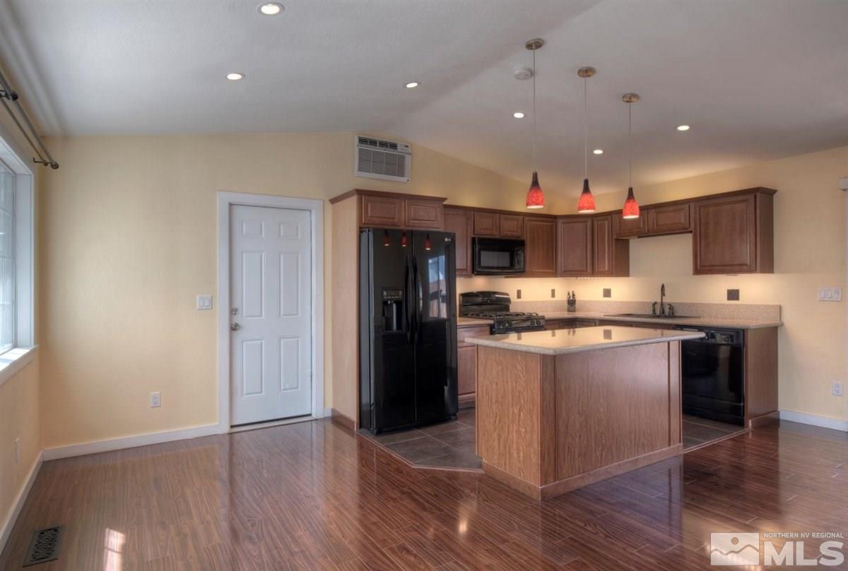 2975 Andrea Street Reno, NV 89503 - Photo 9 of 28 a kitchen with stainless steel appliances granite countertop a refrigerator a sink dishwasher a stove and white countertops with wooden floor