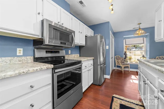 a kitchen with stainless steel appliances granite countertop a stove a refrigerator and a microwave