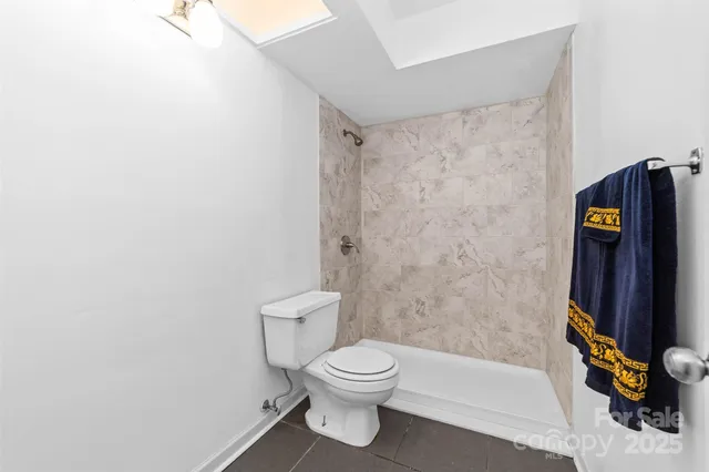 a bathroom with a toilet and a shower