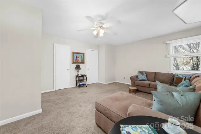 a living room with furniture and a ceiling fan