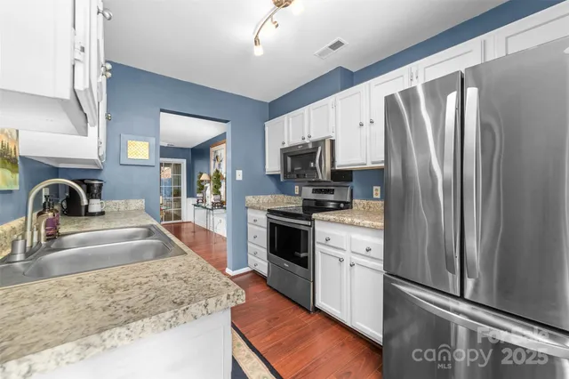 a kitchen with granite countertop a refrigerator and a sink