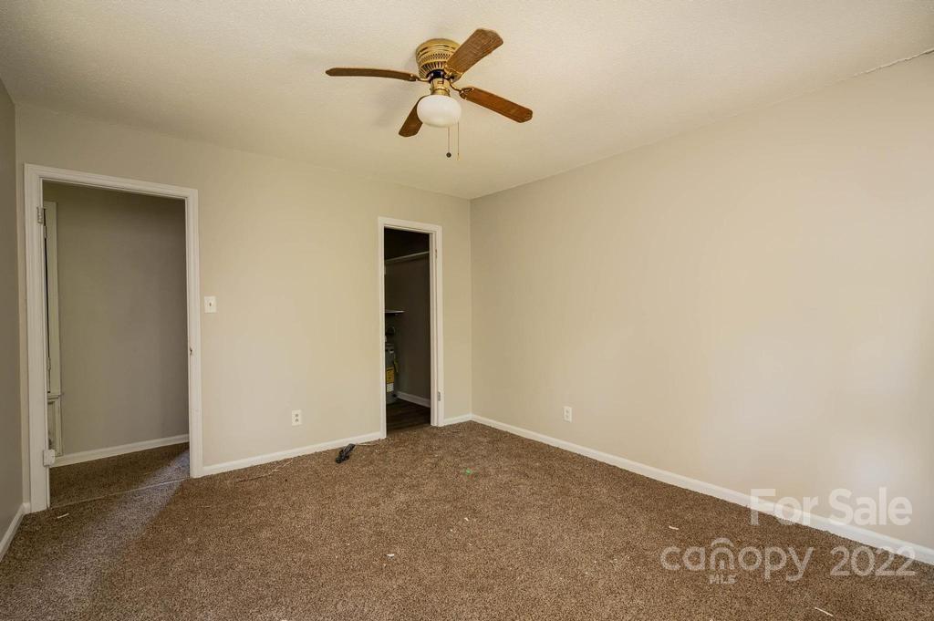 1219 County Home Road Conover, NC 28613 - Photo 18 of 48 an empty room with a ceiling fan and carpet