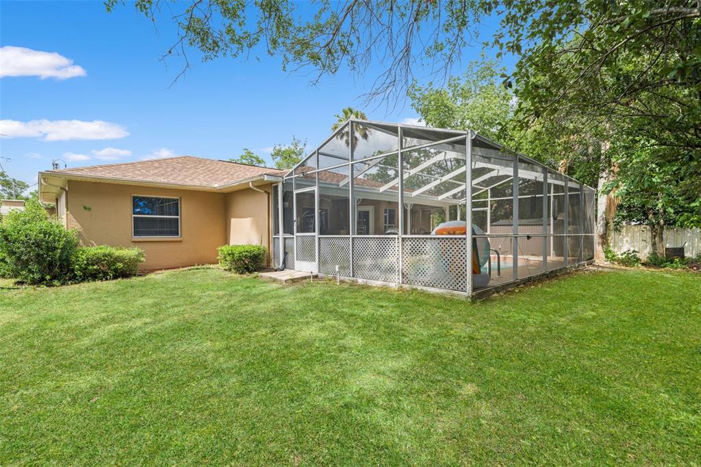 12292 Ronald Street Spring Hill, FL 34609 - Photo 16 of 18 a view of a house with a backyard