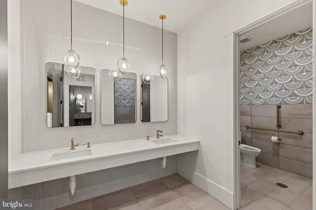 a bathroom with a sink a toilet a mirror and shower