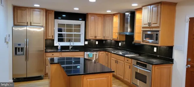 a kitchen with stainless steel appliances granite countertop a stove a sink and a refrigerator