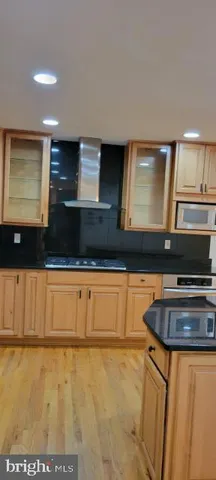 a kitchen with stainless steel appliances granite countertop a sink a stove and a microwave