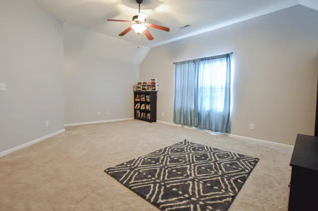 wooden floor in an empty room with a chandelier fan
