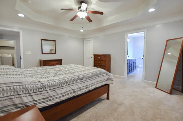 a bedroom with a large bed and a chandelier