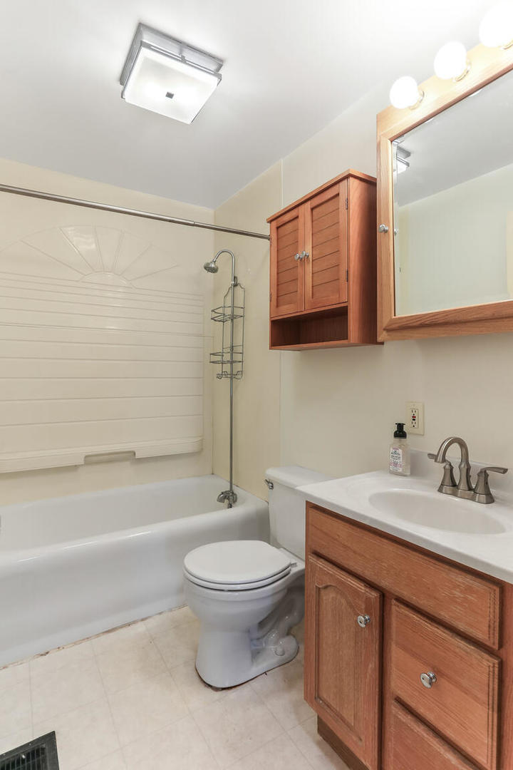 1206 West Healey Street Champaign, IL 61821 - Photo 16 of 42 a bathroom with a granite countertop toilet sink and mirror