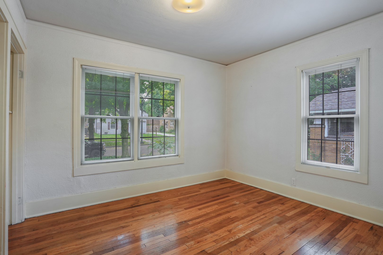 1206 West Healey Street Champaign, IL 61821 - Photo 18 of 42 a view of an empty room with wooden floor and a window