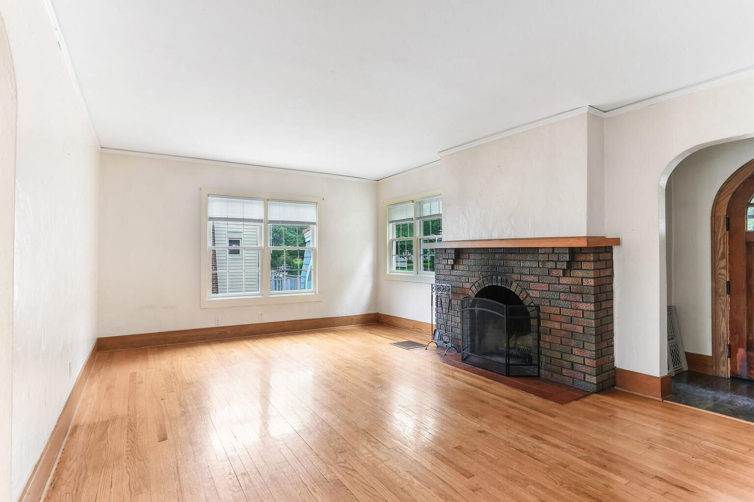 1206 West Healey Street Champaign, IL 61821 - Photo 7 of 42 an empty room with fireplace wooden floor and windows