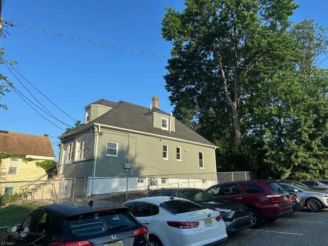 a front view of a house with cars parked