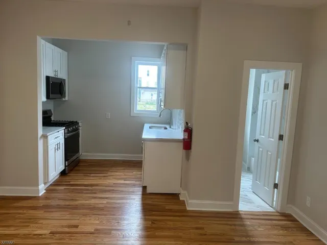 a view of a kitchen with wooden floor and a sink