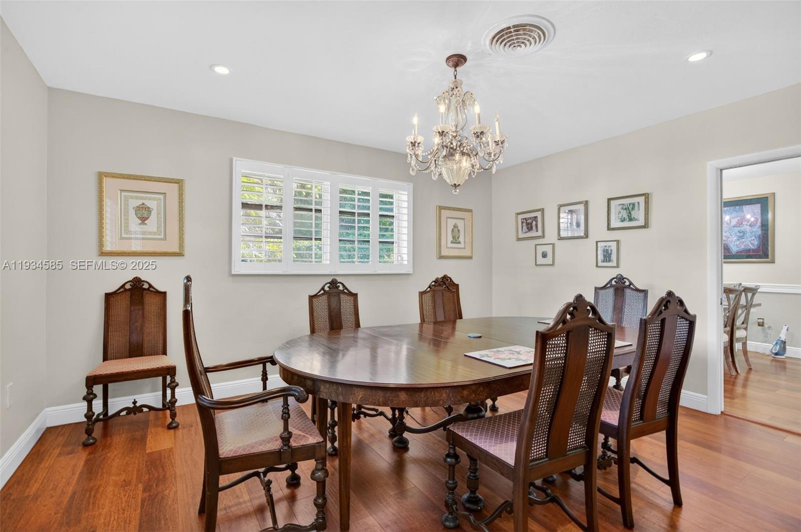 7300 Southwest 116th Terrace Pinecrest, FL 33156 - Photo 20 of 63 a view of a dining room with furniture a chandelier and wooden floor