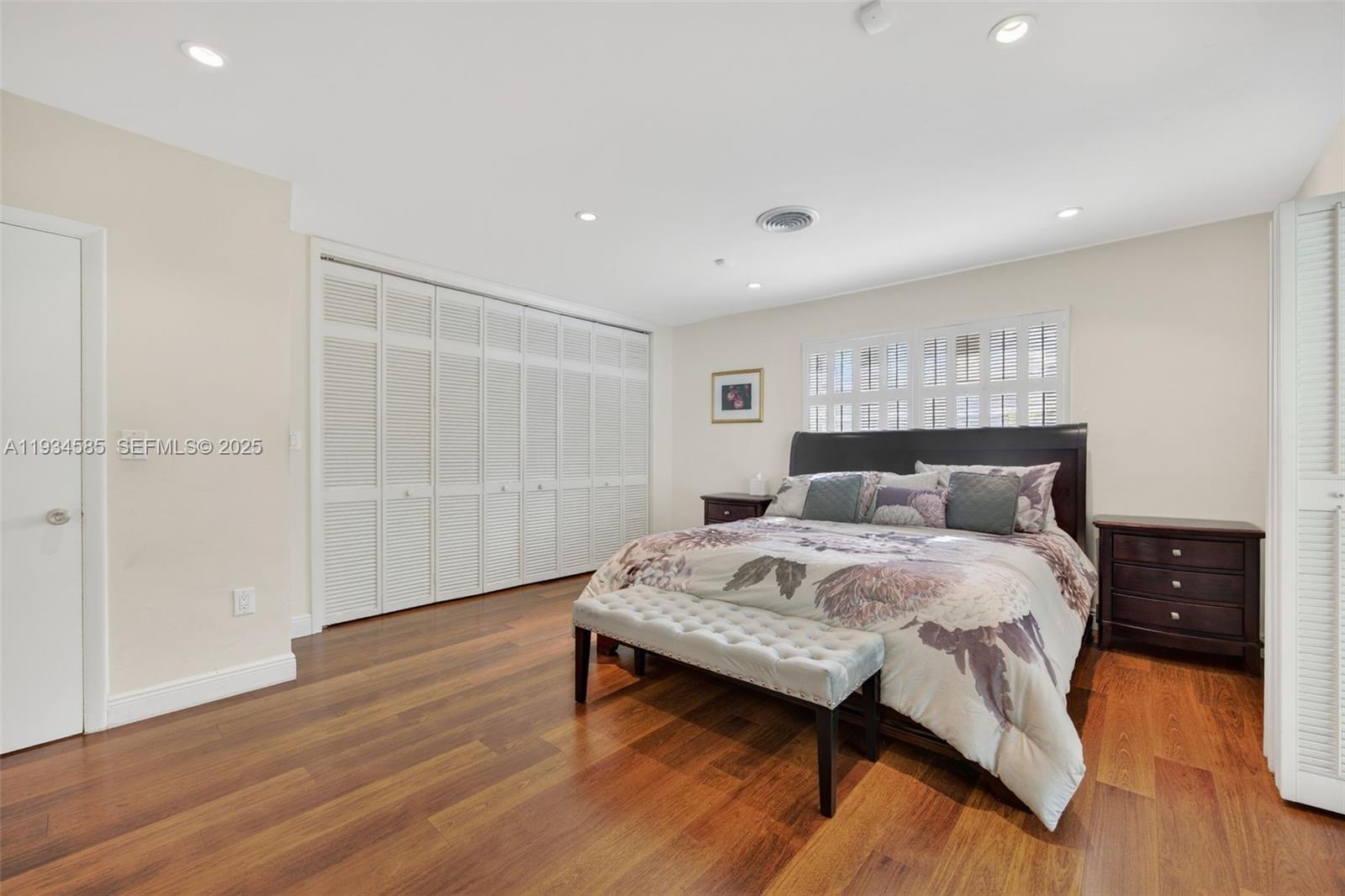 7300 Southwest 116th Terrace Pinecrest, FL 33156 - Photo 30 of 63 a bedroom with a bed and wooden floor