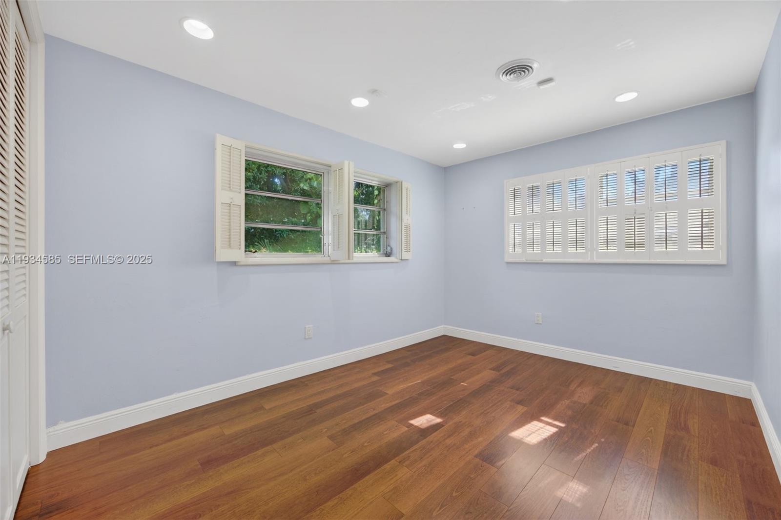 7300 Southwest 116th Terrace Pinecrest, FL 33156 - Photo 33 of 63 a view of an empty room with wooden floor and a window