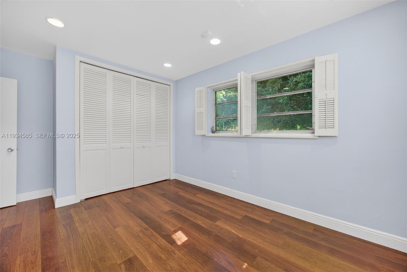 7300 Southwest 116th Terrace Pinecrest, FL 33156 - Photo 35 of 63 a view of an empty room with wooden floor and a window