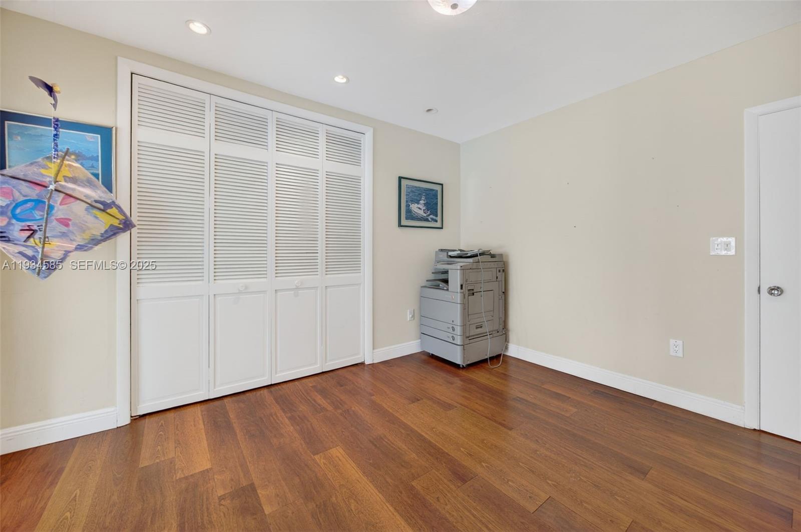 7300 Southwest 116th Terrace Pinecrest, FL 33156 - Photo 45 of 63 an empty room with wooden floor and windows