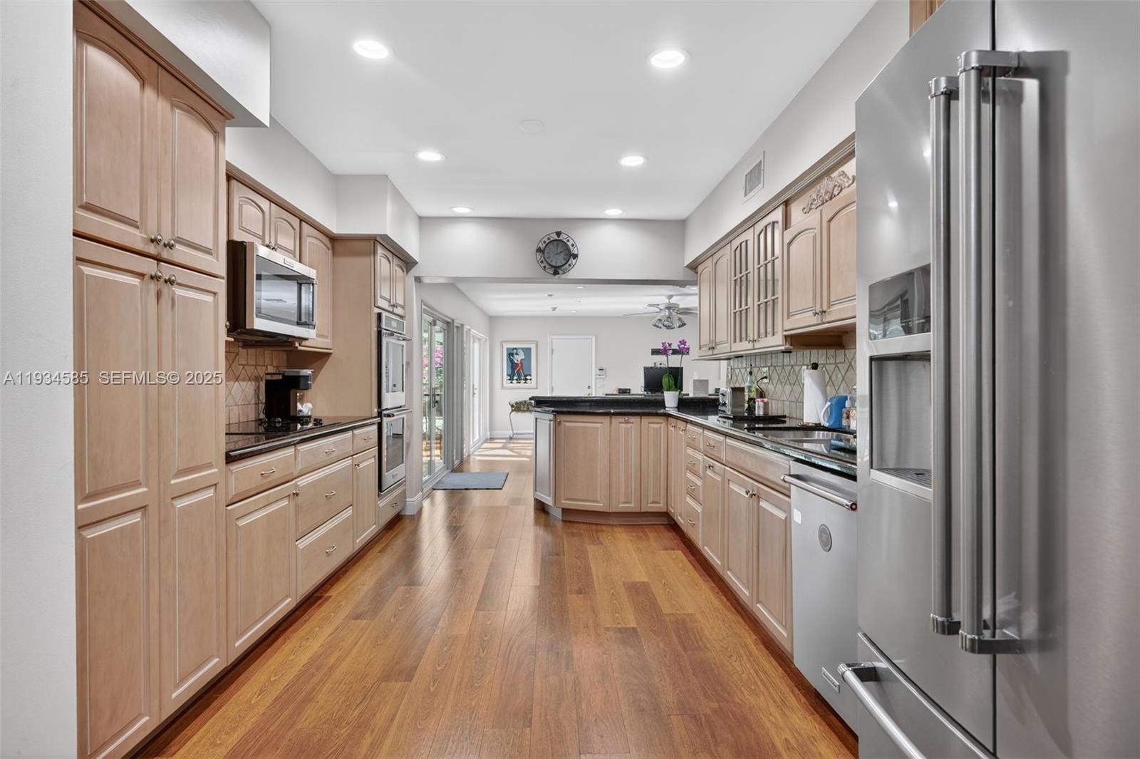 7300 Southwest 116th Terrace Pinecrest, FL 33156 - Photo 5 of 63 a large kitchen with stainless steel appliances granite countertop a refrigerator a stove a sink and a refrigerator