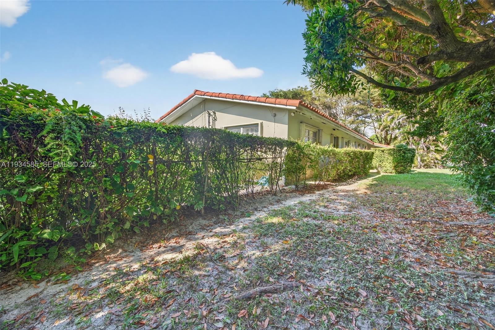 7300 Southwest 116th Terrace Pinecrest, FL 33156 - Photo 58 of 63 a front view of a house with a yard and an trees