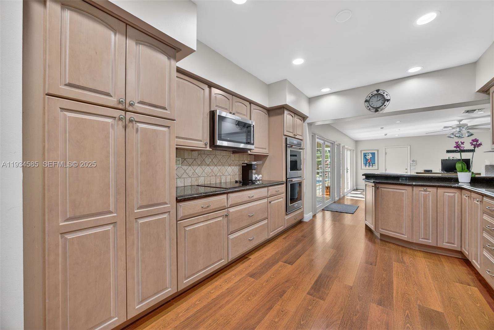 7300 Southwest 116th Terrace Pinecrest, FL 33156 - Photo 8 of 63 a large kitchen with cabinets wooden floor and stainless steel appliances