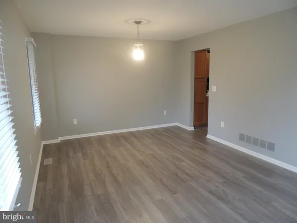 a kitchen with cabinets and wooden floor