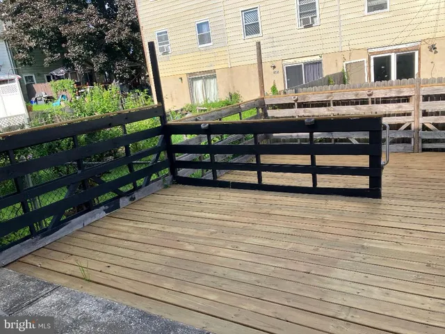 a backyard of a house with wooden floor and outdoor seating