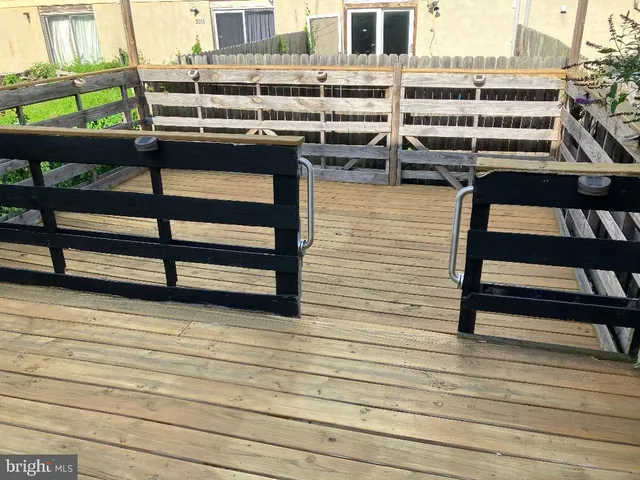 a backyard of a house with wooden floor and outdoor seating