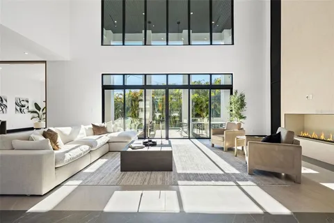 a living room with fireplace furniture and a large window