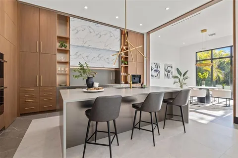 a large kitchen with kitchen island a sink a counter and stainless steel appliances