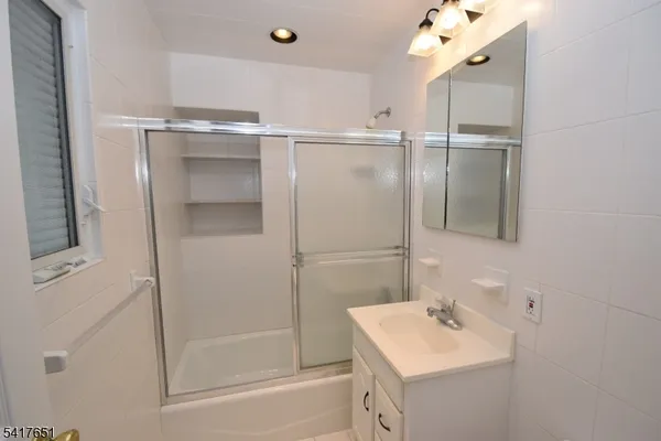 a bathroom with a sink mirror and shower