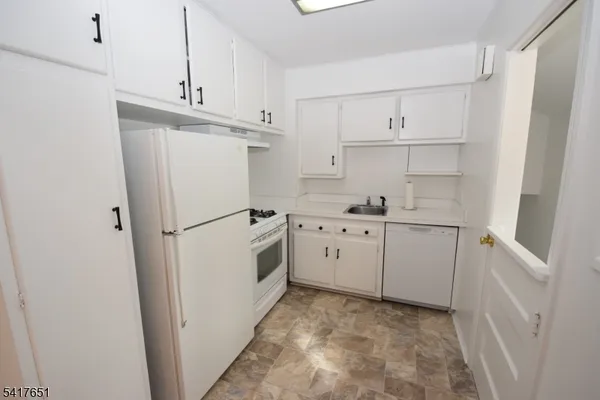 a kitchen with white cabinets and white appliances