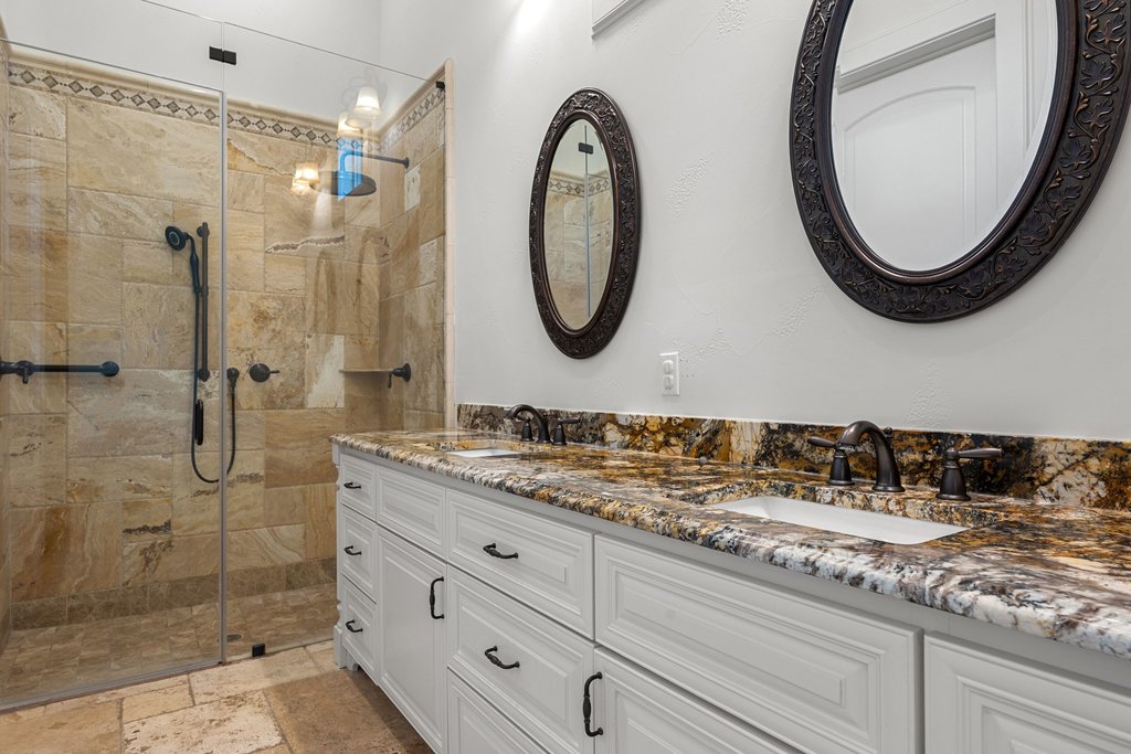 102 Long Point Cove Georgetown, TX 78628 - Photo 32 of 36 a bathroom with a granite countertop sink a mirror and shower
