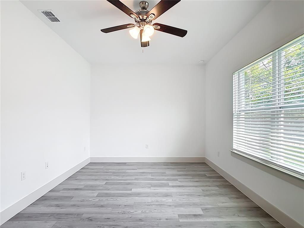 3525 Southwest 163rd Pl Road Ocala, FL 34473 - Photo 19 of 80 a view of an empty room with wooden floor and a window