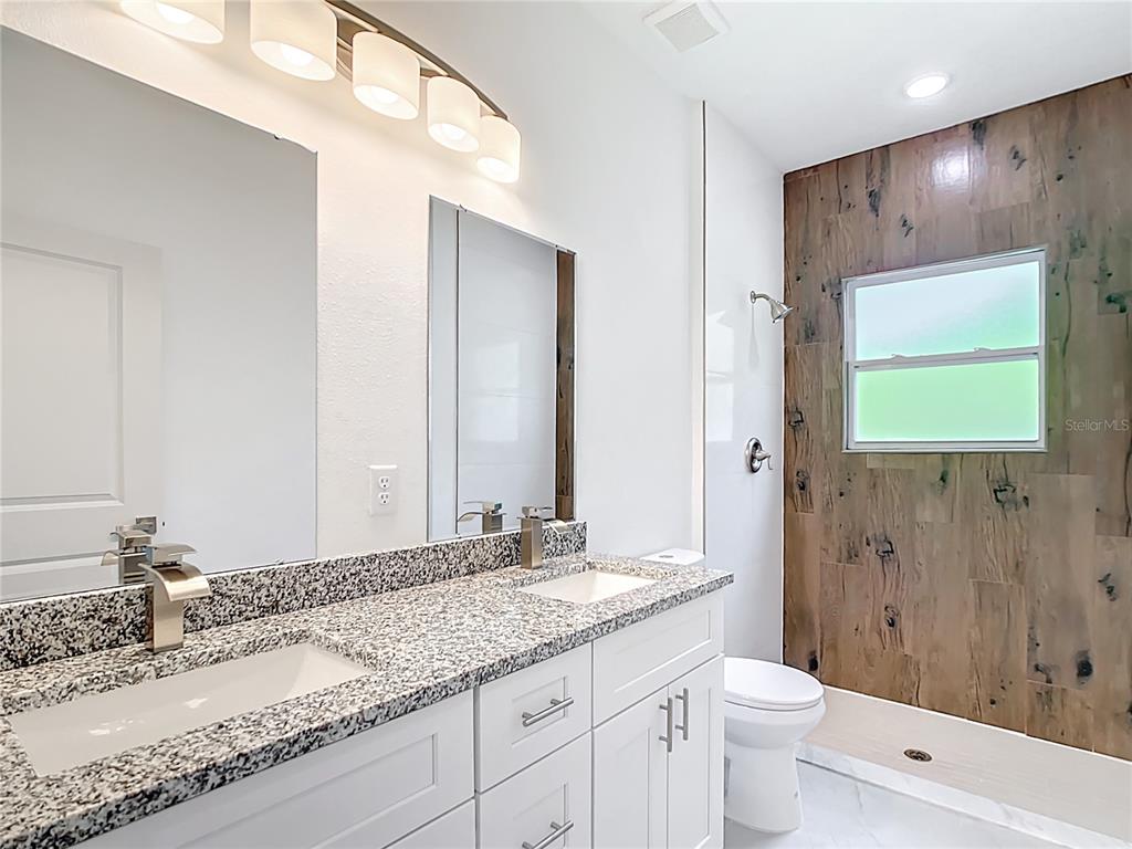 3525 Southwest 163rd Pl Road Ocala, FL 34473 - Photo 26 of 80 a bathroom with a granite countertop sink toilet and shower