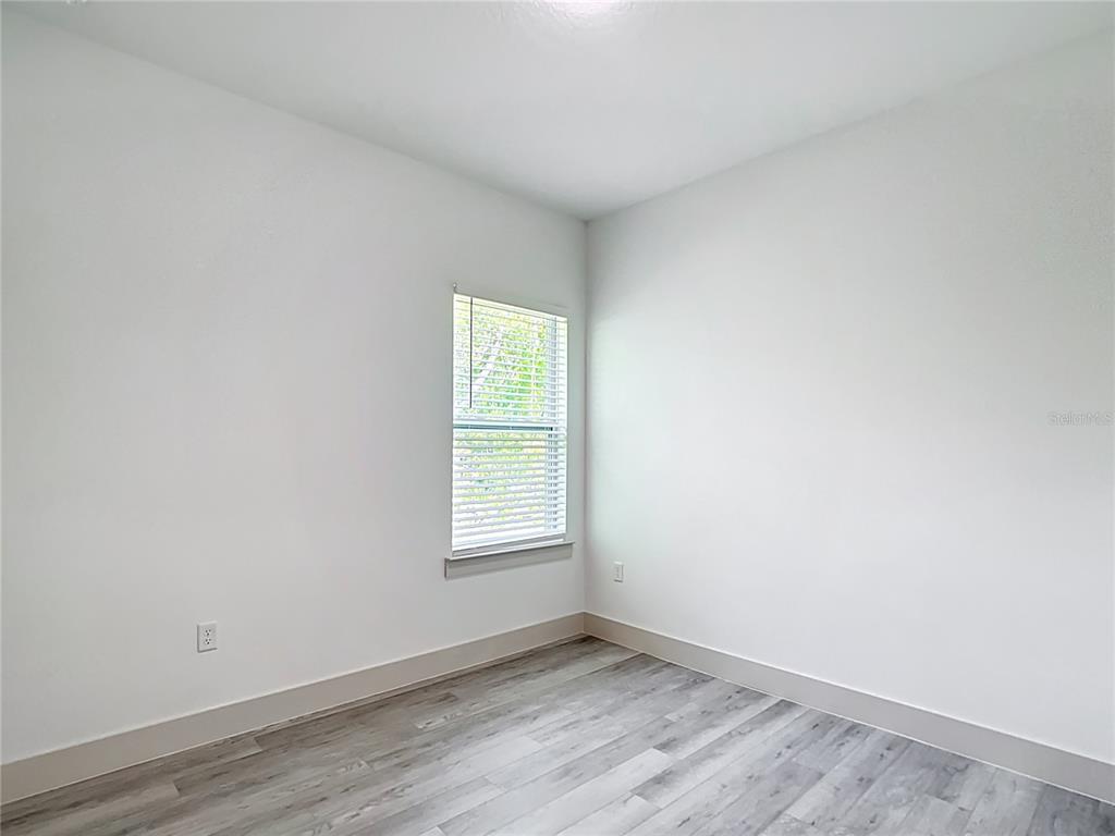 3525 Southwest 163rd Pl Road Ocala, FL 34473 - Photo 30 of 80 an empty room with wooden floor and windows