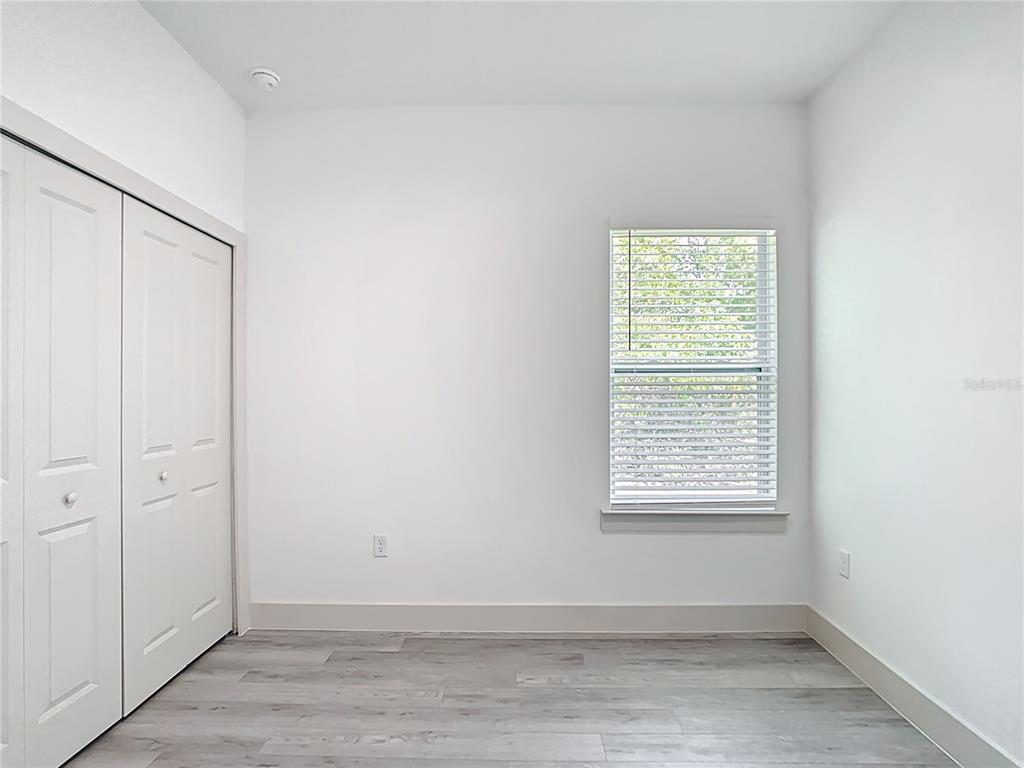 3525 Southwest 163rd Pl Road Ocala, FL 34473 - Photo 33 of 80 an empty room with wooden floor and windows