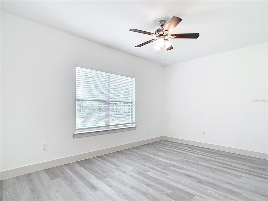 3525 Southwest 163rd Pl Road Ocala, FL 34473 - Photo 44 of 80 an empty room with wooden floor fan and windows